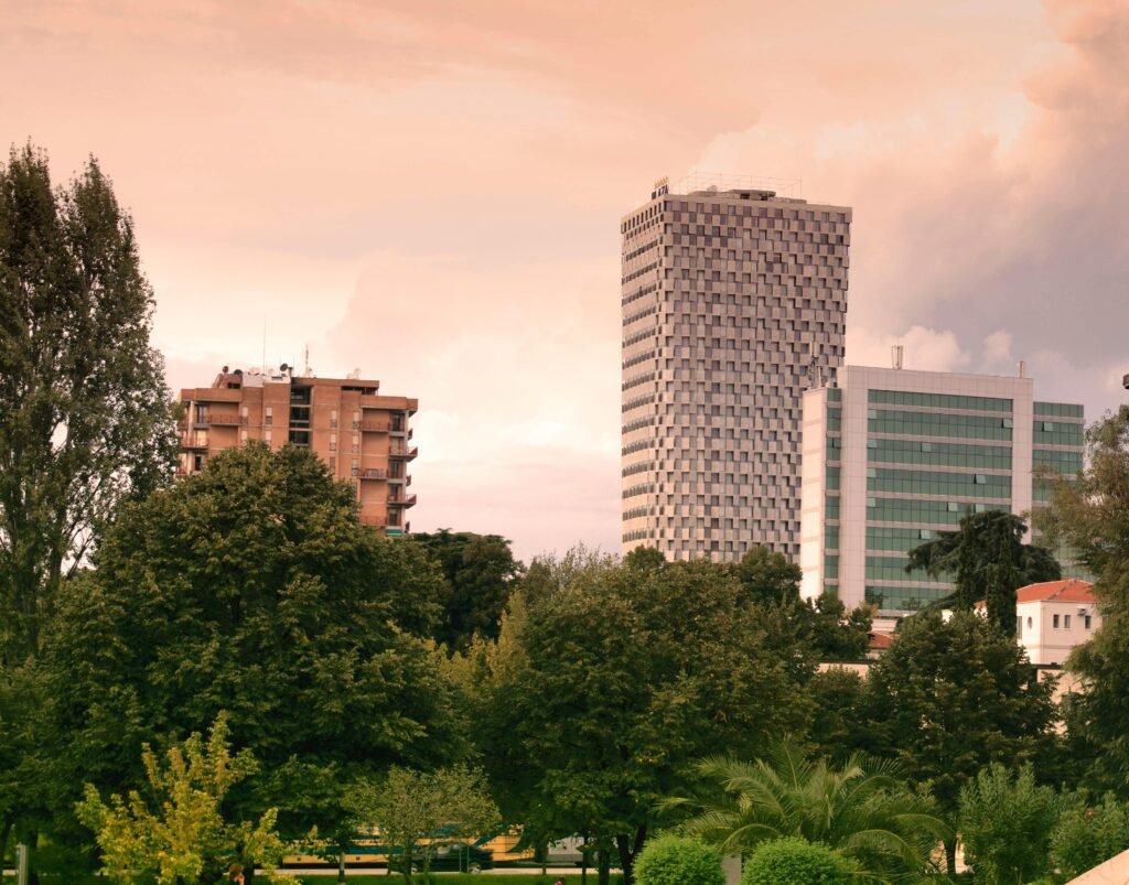 View of modern skyscrapers and lush greenery in Tirana, Albania during daylight.